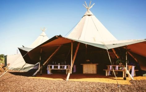 Open Sided Tipi With Rustic Wooden Furniture Inside For A Wedding